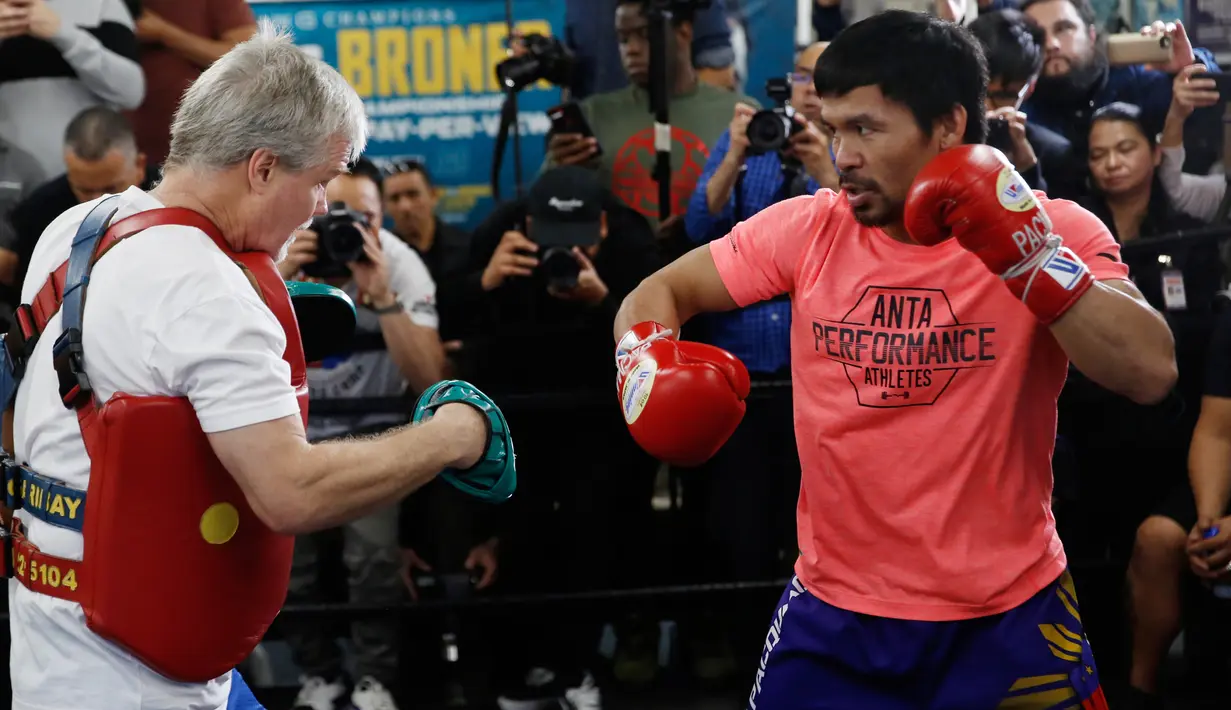Petinju Manny Pacquiao (kanan) berlatih dengan pelatih Freddie Roach di sebuah klub tinju di Los Angeles, AS, Rabu (9/1). Pacquiao akan melawan Adrien Broner pada 19 Januari mendatang. (AP Photo/Damian Dovarganes)