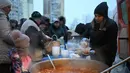 Di tengah kesulitan warga Kyiv, sejumlah sukarelawan dari organisasi World Central Kitchen hadir untuk memberikan bantuan. Tampak dalam foto, para sukarelawan dari organisasi amal makanan yang berbasis di Amerika Serikat (AS), World Central Kitchen, membagikan makanan hangat kepada warga setempat di sebuah kawasan perumahan di Kyiv yang mengalami pemadaman listrik dan air akibat serangan Rusia yang menghantam sektor energi, Kamis 22 Januari 2026. (Sergei GAPON/AFP)