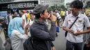 Penyandang disabilitas tuna rungu dan tuna wicara berkumpul memperingati Hari Tuli Internasional di arena Car Free Day, Jakarta, Minggu (25/9). Dalam kampanye ini, mereka memperagakan bahasa isyarat kepada warga masyarakat. (Liputan6.com/Faizal Fanani)