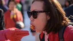 Seorang wanita mencoba kimchi selama festival pembuatan kimchi di Seoul (2/11). Festival pembuatan kimchi ini menandai awal musim dingin. (AFP Photo/Ed Jones)