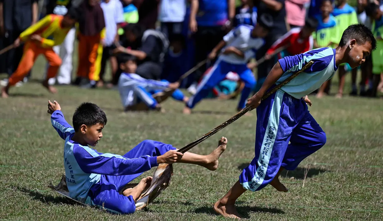 Siswa mengikuti permainan tradisional tarik upih pinang (tarek situek) pada Festival Permainan Tradisional Anak di Desa Wisata Lubok Sukon, Kecamatan Ingin Jaya, Aceh Besar, Aceh, Sabtu (25/7/2026). (AFP/ Chaideer Mahyuddin)