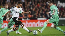 Gelandang Valencia, Francis Coquelin berebut bola dengan gelandang Real Madrid, Toni Kroos pada pertandingan lanjutan La Liga Spanyol di Stadion Mestalla (15/12/2019). Madrid bermain imbang 1-1 atas Valencia. (AP Photo/Alberto Saiz)