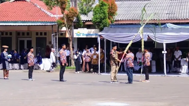 Bupati Kudus Samani Intakoris menerima sebatang tebu yang siap dimasukan ke mesin giling menandai proses produksi PG Rendeng Kudus. (Liputan6.com/Arief Pramono)