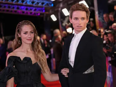 Aktor Inggris Eddie Redmayne (kanan) dan istrinya Hannah Bagshawe berpose untuk fotografer saat tiba untuk pemutaran perdana film 'The Good Nurse' pada acara London Film Festival di London, Inggris, 10 Oktober 2022. Eddie Redmayne menggandeng mesra sang istri pada acara tersebut. (Photo by Vianney Le Caer/Invision/AP)