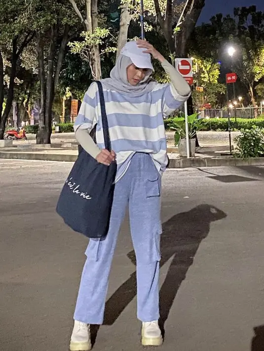 Zaskia Adya Mecca tampil dengan oversize kaos bergaris. Atasan didominasi biru putih pun dipadukan manset abu-abu yang serasi dengan kerudungnya. Ia juga mengenakan celana cargo baby blue. (@zaskiadyamecca)