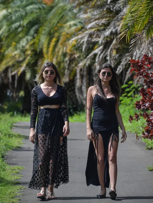 Kembar transgender Brasil, Sofia (kiri) dan Mayla berjalan di sebuah taman di Campinas, sekitar 100 km dari Sao Paulo, pada 27 Februari 2021. Kembar 19 tahun tersebut secara bersamaan telah melakukan operasi kelamin mereka pada 13 dan 14 Februari lalu. (Nelson ALMEIDA / AFP)