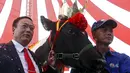 Nguyen Van Huynh (kanan) saat berpose setelah sapinya memenangkan kontes kecantikan di Moc Chau, Vietnam, Kamis (15/10/2015).  Sapinya mempunyai berat 710 kg dan menyediakan sekitar 59,6 kg susu setiap hari. (REUTERS/Kham)