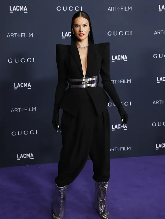 Alessandra Ambrosio berpose saat menghadiri acara LACMA Art+Film Gala di Los Angeles County Museum of Art di Los Angeles, California, pada 5 November 2022. Celana setelan termasuk beberapa lipatan, mirip dengan yang ditemukan di celana Cossack, terutama setelah kaki dimasukkan ke dalam sepasang sepatu bot logam. (AFP/Michael Tran)
