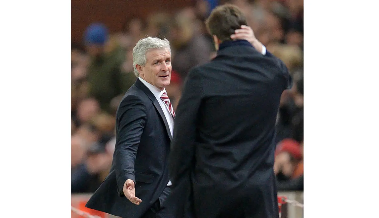 Pelatih Tottenham Hotspur, Mark Hughes (kiri) saat berbincang dengan pelatih Tottenham Hotspur, Mauricio Pochettino pada lanjutan Liga Inggris di Stadion Britannia, Stoke, Selasa (19/4/2016) dini hari WIB. (AFP/Oli Scarff)