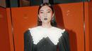 Isyana memadukan atasan warna hitam dengan detail kerah bib ruffle yang dipadukan dengan rok rajut dengan potongan slit warna senada. (Instagram/isyanasarasvati).
