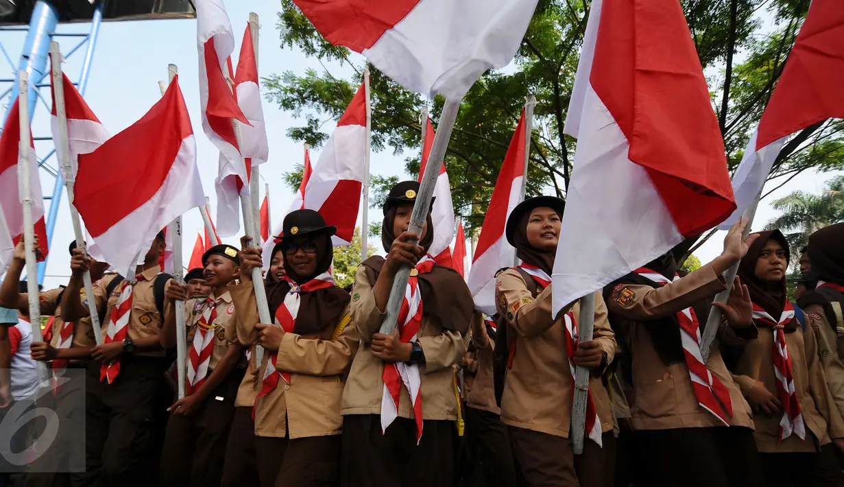 Puluhan anggota Pramuka memgibarkan bendera Merah Putih saat Kirab Kebangsaan Indonesia Raya di Cibinong, Kab Bogor, Minggu (14/5). Kirab diikuti puluhan organisasi kepemudaan se Kabupaten Bogor. (Liputan6.com/Helmi Fithriansyah)