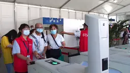 Para sukarelawan membantu pengunjung melewati pintu masuk di Pameran Buku Shanghai 2020 di Shanghai, China (12/8/2020). Pameran Buku Shanghai 2020 dimulai 12 dan 18 Agustus harus mendaftar dengan nama asli mereka, menunjukkan kode kesehatan, memakai masker, dan memeriksa suhu. (Xinhua/Ren Long)