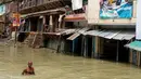 Warga melintasi banjir yang menggenangi kawasan Allahabad, India (26/8). Sekitar 300 orang dikabarkan tewas dalam peristiwa banjir bandang tersebut. (REUTERS/Jitendra Prakash)