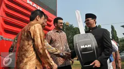 Basuki T Purnama (kanan) menerima kunci bus simbolis saat peluncuran bus-bus baru dan hotline Transjakarta di monas, Jakarta, Senin (22/6/2015).  Sebanyak 20 unit bus gandeng Transjakarta buatan eropa resmi diluncurkan. (Liputan6.com/Herman Zakharia)