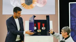 Presiden Olimpiade dan Paralimpiade Paris 2024, Tony Estanguet (kiri) dan mantan Paralimpaian Prancis, Beatrice Hess membuka kotak yang berisikan medali Paralimpiade saat peresmian medali Olimpiade dan Paralimpiade untuk Olimpiade Paris 2024 yang berlangsung di Paris, Prancis, Kamis (08/02/2024). (AFP/Dimitar Dilkoff)