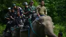 Polisi militer Indonesia dan penjaga taman nasional dibantu gajah jinak melakukan patroli keliling hutan di kawasan hutan Ulue Masen, provinsi Aceh, Sabtu (27/4/2019). Patroli keliling tersebut guna menjaga kelestarian alam dan satwa liar dari ancaman kepunahan. (CHAIDEER MAHYUDDIN/AFP)