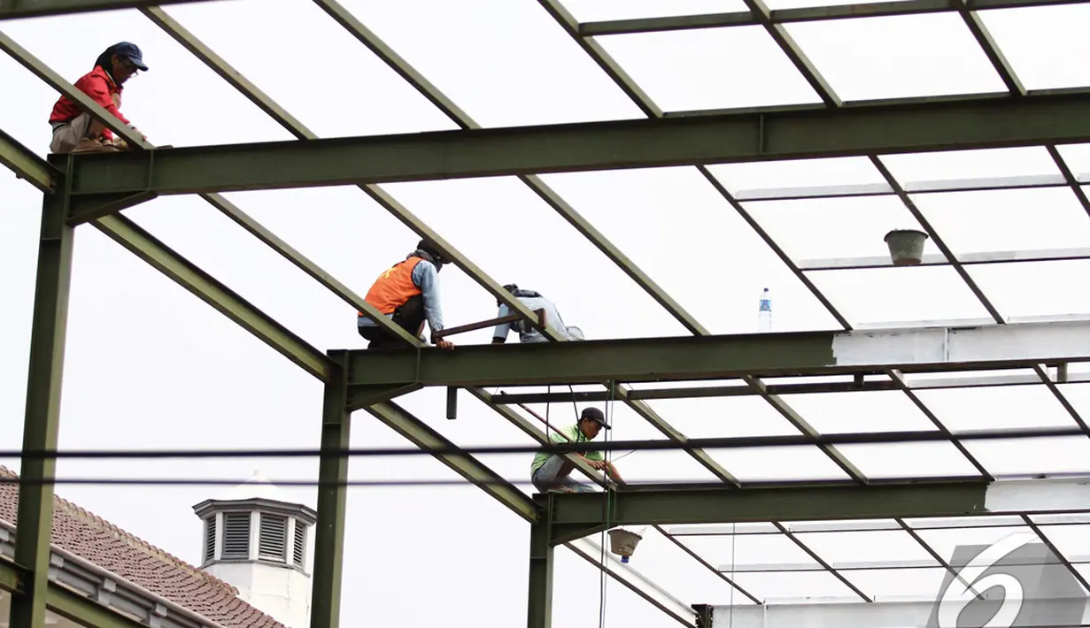 Pekerja sedang mengecat rangka Ruang Tunggu Penumpang di Stasiun Senen, Jakarta, Senin (24/11/2014). (Liputan6.com/Faizal Fanani)