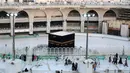Sejumlah orang berjalan di Masjidil Haram di Mekah, Arab Saudi, Kamis (5/3/2020). Penutupan sementara Masjidil Haram dan Masjid Nabawi dilaksanakan di luar waktu salat. (ABDEL GHANI BASHIR/AFP)