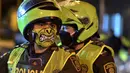 Petugas polisi menggunakan masker wajah sebagai langkah pencegahan terhadap penyebaran virus corona baru, COVID-19, di Cali, Kolombia pada 20 Maret 2020. Masker dijadikan masyarakat pilihan untuk mencegah penyebaran virus corona yang terus meningkat di seluruh dunia.  (Luis ROBAYO / AFP)
