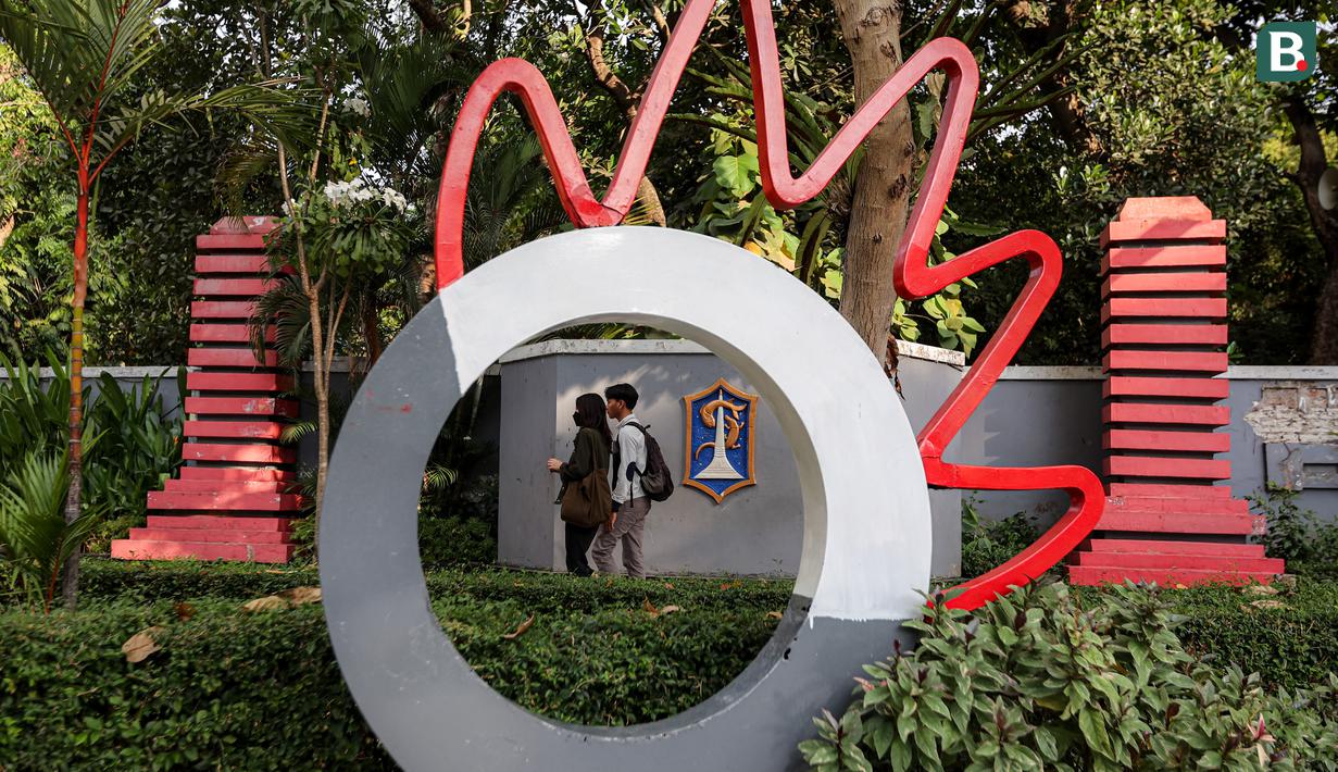 Sepasang pelajar sedang berjalan di pedestrian Taman Bungkul yang terletak di Jalan Raya Darmo, Wonokromo, Surabaya, Selasa (14/11/2023). (Bola.com/Bagaskara Lazuardi)