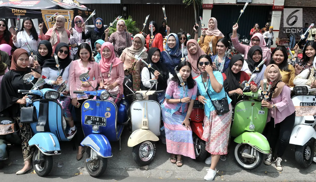 Anggota komunitas Vespa se-Jabodetabek foto bersama di sela konvoi dalam rangka memperingati Hari Kartini di Jakarta, Minggu (21/4). Dalam konvoi ini para pengendara vespa mengenakan kebaya bagi perempuan dan batik serta lurik bagi laki-laki. (merdeka.com/Iqbal Nugroho)