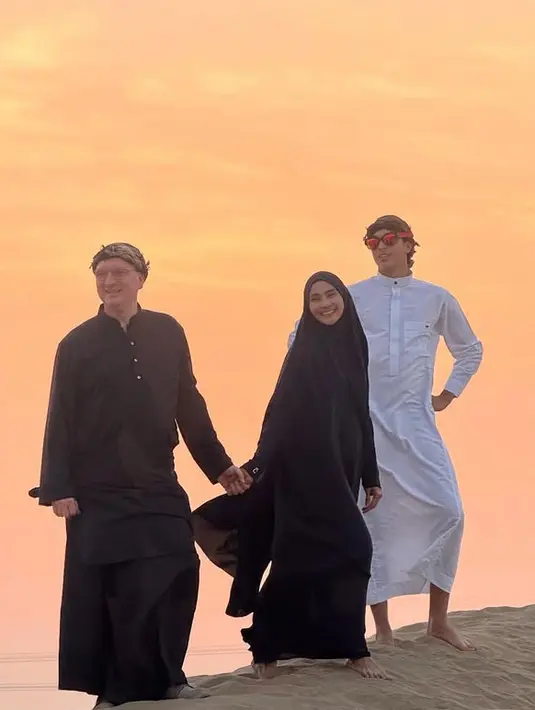 Ketiganya pun menikmati keindahan gurun pasir, sang suami mengenakan pakaian hitam dah Eddy mengenakan gamis putihnya. [@maudykoesnaedi]