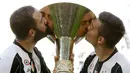 Penyerang Juventus, Gonzalo Higuain dan Paulo Dybala mencium trofi Liga Italia di Juventus Stadium, Turin, (21/5). Juventus menjadi tim pertama dalam sejarah yang bisa meraih enam scudetto secara beruntun. (AP Photo/Antonio Calanni)