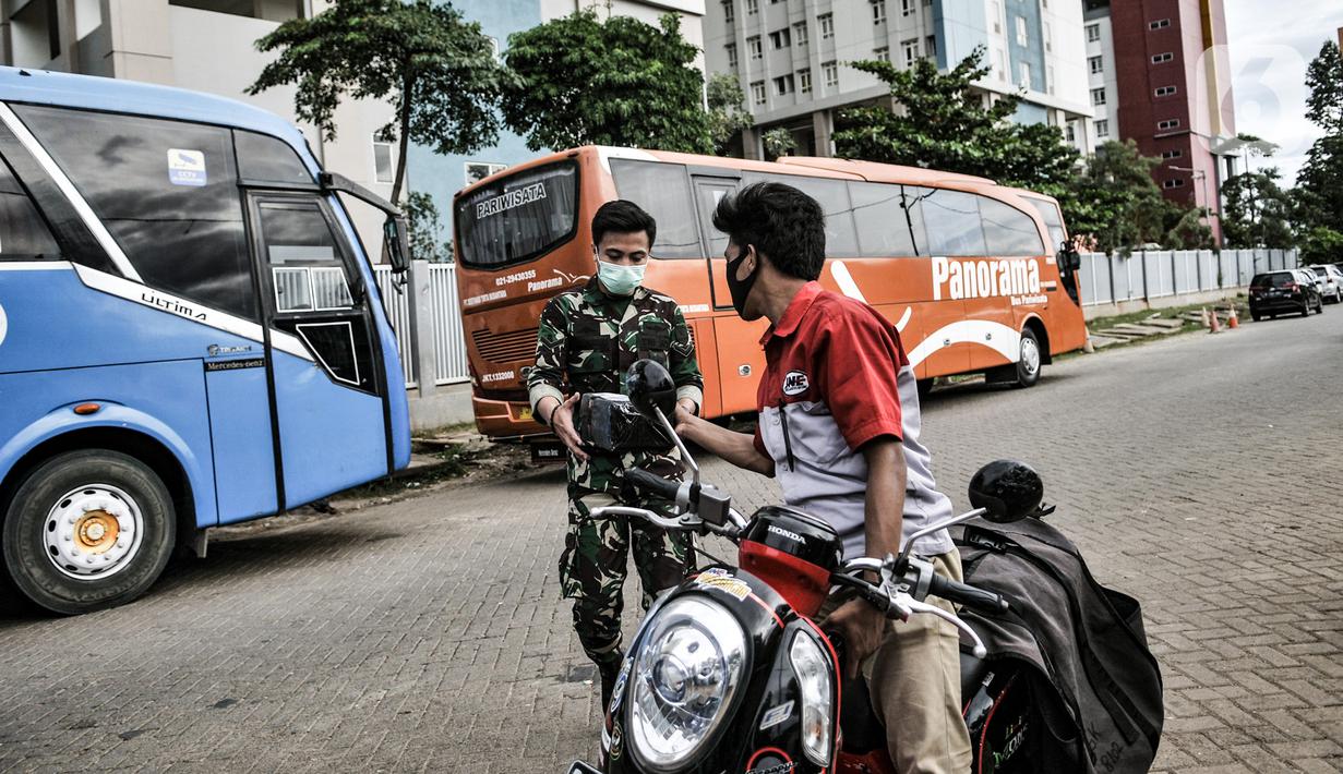 Petugas kurir JNE saat mengantarkan paket ke anggota TNI yang sedang bertugas di Wisma Atlet Pademangan, Jakarta, Selasa (29/12/2020). Beralihnya warga ke belanja melalui e-commerce karena tidak harus keluar rumah guna mencegah penularan virus corona COVID-19. (merdeka.com/Iqbal S. Nugroho)