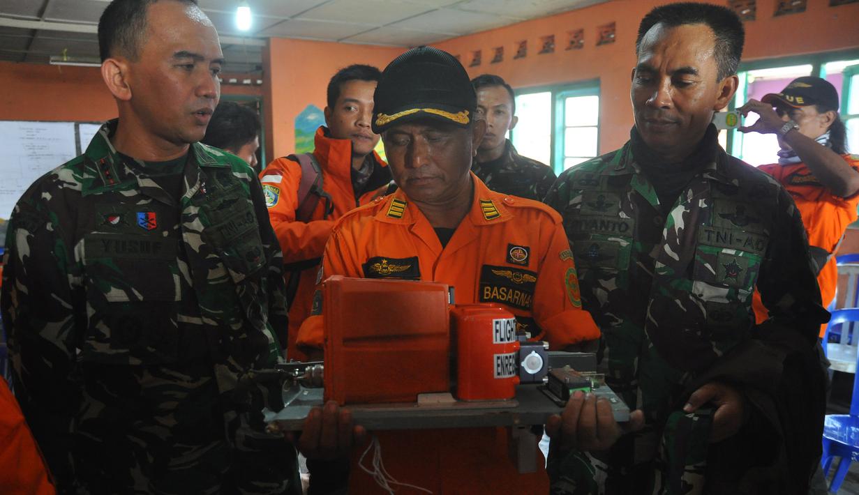 Petugas dari Basarnas memegang sebuah kotak hitam atau Black Box dari helikopter Basarnas yang jatuh di Temanggung, Jawa Tengah (3/7). Helikopter yang membawa 8 orang tersebut jatuh saat perjalanan menuju lokasi letusan kawah Dieng. (AFP Photo/STR)