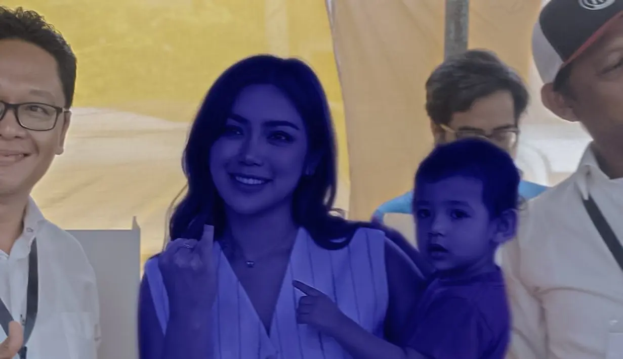 Jessica Iskandar terlihat mencoblos dengan menggendong sang anak. Ia mengenakan cropped vest bercorak garis, dipadu celana panjang, gaya unik pamer jari kelingking dengan noda tinta sambil gendong anak. [Foto: Instagram/inijedar]