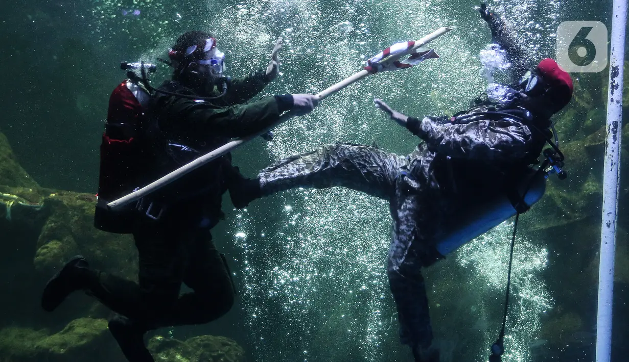 Penyelam mementaskan drama teatrikal yang bertajuk "Semangat perjuangan" di akuarium utama Sea World, Ancol, Jakarta, Selasa (10/11/2020). Pertunjukan dengan latar belakang Pertempuran Surabaya itu digelar pada 7-10 November untuk memperingati Hari Pahlawan Nasional. (Liputan6.com/Johan Tallo)