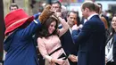 Kate Middleton asyik berdansa dengan seorang aktor yang mengenakan kostum Paddington di stasiun kereta Paddington, London, Senin (16/10). Kate memberi kejutan dalam acara yang melibatkan anak-anak dari yayasan amal yang didukungnya (Chris J Ratcliffe/AFP)
