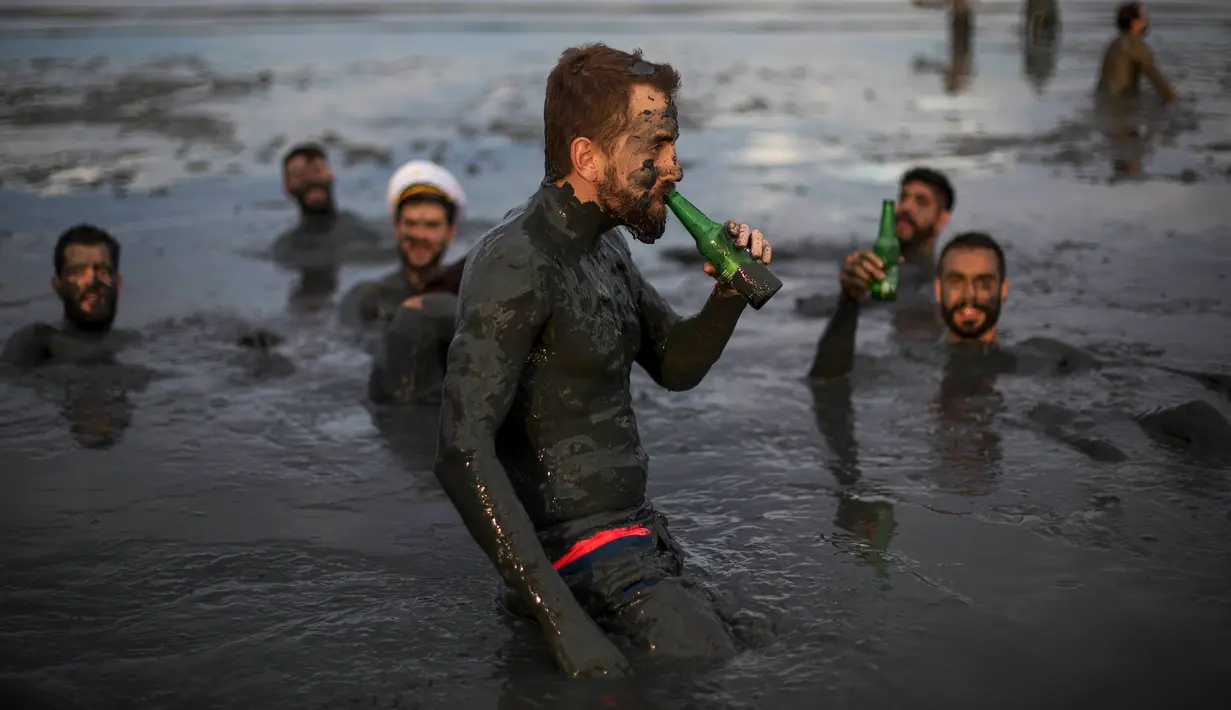 Sejumlah pria dengan tubuh yang dipenuhi lumpur mengikuti festival tradisional "Bloco da Lama" atau "Mud Street" di Paraty, Brasil (25/2). (AP Photo / Mauro Pimentel)