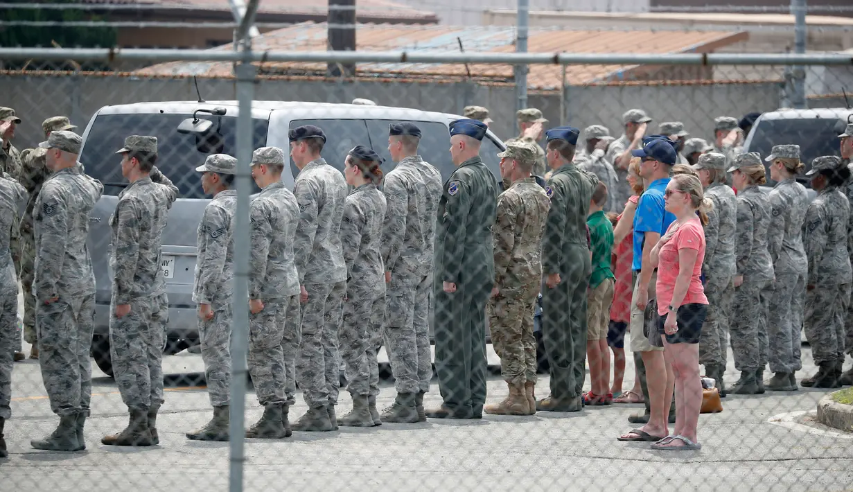 Tentara Amerika Serikat (AS) dan sejumlah orang memberi hormat kepada kendaraan yang mengangkut 55 jenazah tentara AS yang tewas selama Perang Korea di Pangkalan Udara Osan, Pyeongtaek, Korea Selatan, Jumat (27/7). (Kim Hong-Ji/Pool Photo via AP)