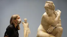 Seorang pegawai museum melihat ke arah patung marmer Crouching Venus, Romawi, abad ke-2 M, saat jumpa pers di The British Museum di London, Senin, (24/8/2020). Rute satu arah baru mengitari galeri Lantai Dasar akan memungkinkan pengunjung mengakses ribuan objek. (AP Photo/Kirsty Wigglesworth)