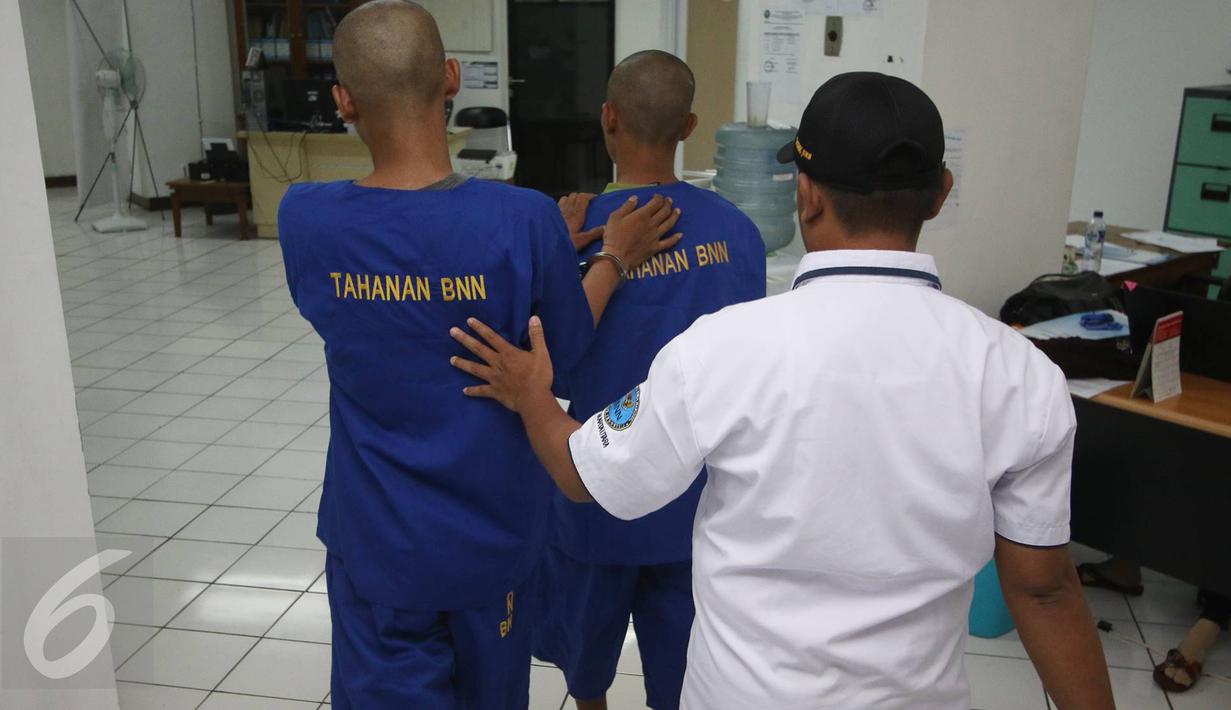 Petugas BNN membawa dua tersangka berinisial H dan TS di kantor BNN Kota Jakarta Utara, Selasa (15/11). BNN Kota Jakarta Utara berhasil mengamankan barang bukti berupa sabu seberat 15,12 gram serta 50 butir ekstasi. (Liputan6.com/Immanuel Antonius)