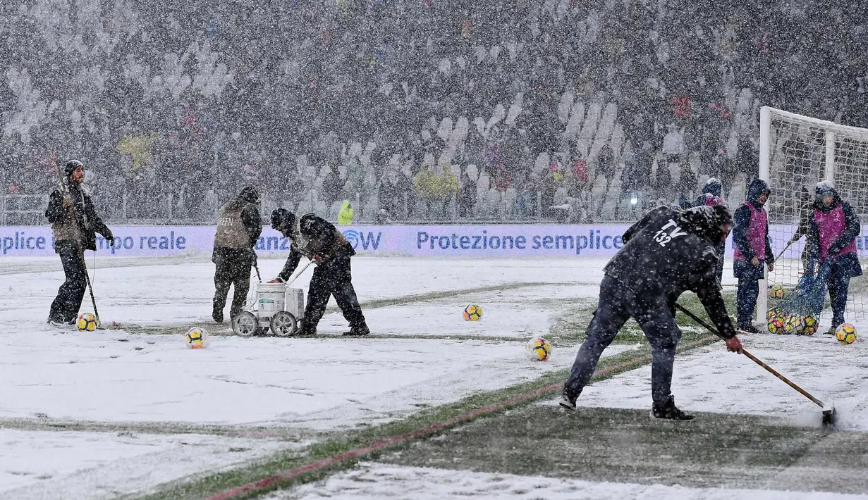 Pekerja membersihkan salju di Allianz Stadium di Turin, Italia, (25/2). Juventus kini berada di posisi kedua dengan 65 poin, selisih satu poin dengan Napoli di puncak klasemen. (Alessandro Di Marco / ANSA via AP)