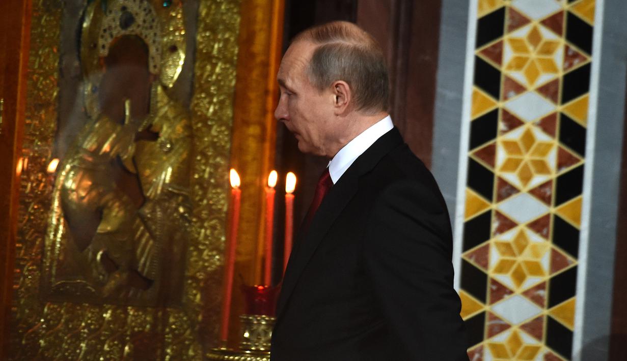 Presiden Rusia, Vladimir Putin saat mengikuti prosesi Paskah Ortodoks di Gereja Katedral Kristus Juru Selamat di Moskow, Rusia,(16/4). (AFP Photo / Vasily Maximov)