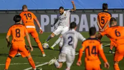 Striker Real Madrid, Karim Benzema, melepaskan tendangan saat melawan Valencia pada laga Liga Spanyol di Stadion Alfredo Di Stefano, Minggu (14/2/2021). Real Madrid menang dengan skor 2-0. (AP/Manu Fernandez)