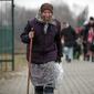Seorang wanita tua memegang tongkat saat pengungsi, kebanyakan wanita dan anak-anak, tiba di perbatasan di Medyka, Polandia, Sabtu (5/3/2022). Mereka melarikan diri dari invasi Rusia di Ukraina. (AP Photo/Visar Kryeziu)