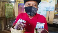 Kusmana, 62 tahun, salah satu panitia kurban HKTI Garut, Jawa Barat, menunjukan bungkus besek dari bambu untuk mendistribusikan daging kurban HKTI Garut. (Liputan6.com/Jayadi Supriadin)