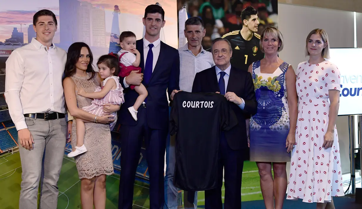 Kiper asal Belgia Thibaut Courtois berpose dengan presiden Real Madrid, Florentino Perez dan kerabatnya selama presentasi dirinya menjadi pemain Real Madrid di stadion Santiago Bernabeu (9/8). (AFP Photo/Javier Soriano)