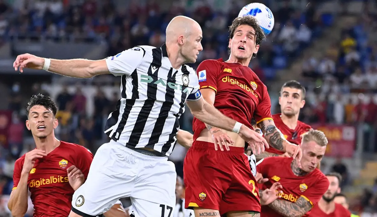 Pemain Udinese Bram Nuytinck (kiri) berebut bola dengan pemain AS Roma Nicolo Zaniolo pada pertandingan Serie A Liga Italia di Olympic Stadium, Roma, Italia, 23 September 2021. AS Roma menang 1-0. (Alberto PIZZOLI/AFP)