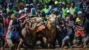 Orang-orang bersorak saat seorang joki bersiap menaiki gerobak saat acara Karapan Sapi Brujul di Probolinggo, Jawa Timur pada Minggu 24 Mei 2026. (Juni KRISWANTO/AFP)