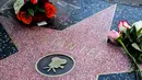 Penggemar meletakkan memorabilia di atas bintang Walk of Fame milik Stan Lee di California, Senin (12/11). Stan Lee, kreator Captain America dan beberapa tokoh superhero Marvel lainnya, meninggal dunia di usia 95 tahun. (Gabriel Olsen/Getty Images/AFP)
