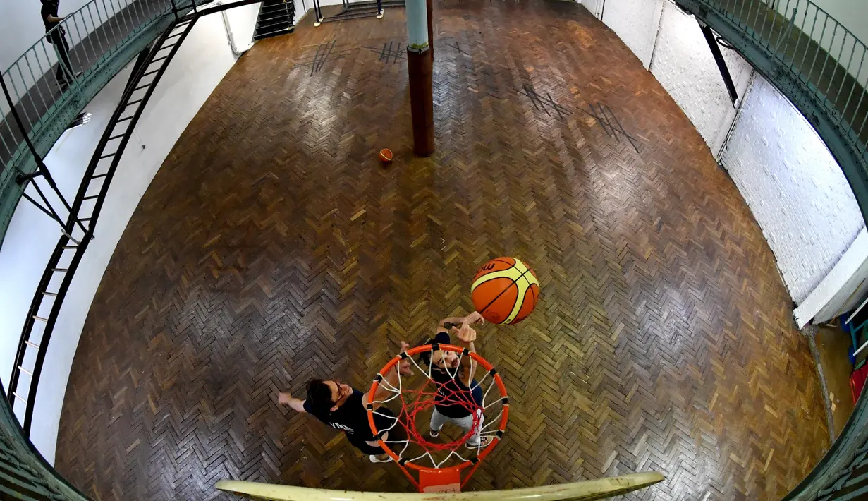 Pemain berlatih di lapangan basket tertua di dunia di Paris, Prancis, Kamis (31/5). Lapangan ini difungsikan pada tahun 1893 atau dua tahun setelah permainan ini diciptakan. (GERARD JULIEN/AFP)