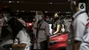 SPG berdiri dekat mobil yang dipamerkan di Indonesia International Motor Show (IIMS) Hybrid 2021, JiExpo Kemayoran, Jakarta, Kamis (16/4/2021). Acara digelar secara daring dan kunjungan langsung dengan pembatasan kapasitas dan penerapan protokol kesehatan COVID-19. (Liputan6.com/JohanTallo)