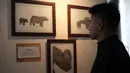 Seorang pengunjung melihat-lihat karya dalam pameran seni badak Sumatera di Perpustakaan Nasional Indonesia, Jakarta Pusat, Jumat (19/1). Pameran bertajuk 'Harta Karun Tersembunyi Indonesia' ini akan berlangsung tiga hari. (Liputan6.com/Arya Manggala)