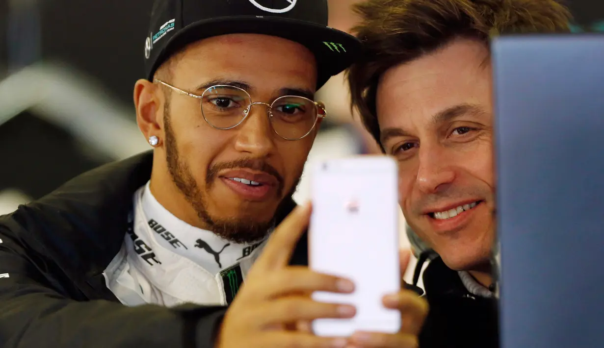 Lewis Hamilton berselfie dengan rekannya saat bersiap untuk memulai latihan kedua pers Formula One Grand Prix di Melbourne, Australia, (17/03/16). Ia sempat menjadi juara dunia termuda sepanjang sejarah F1. (REUTERS/Brandon Malone)