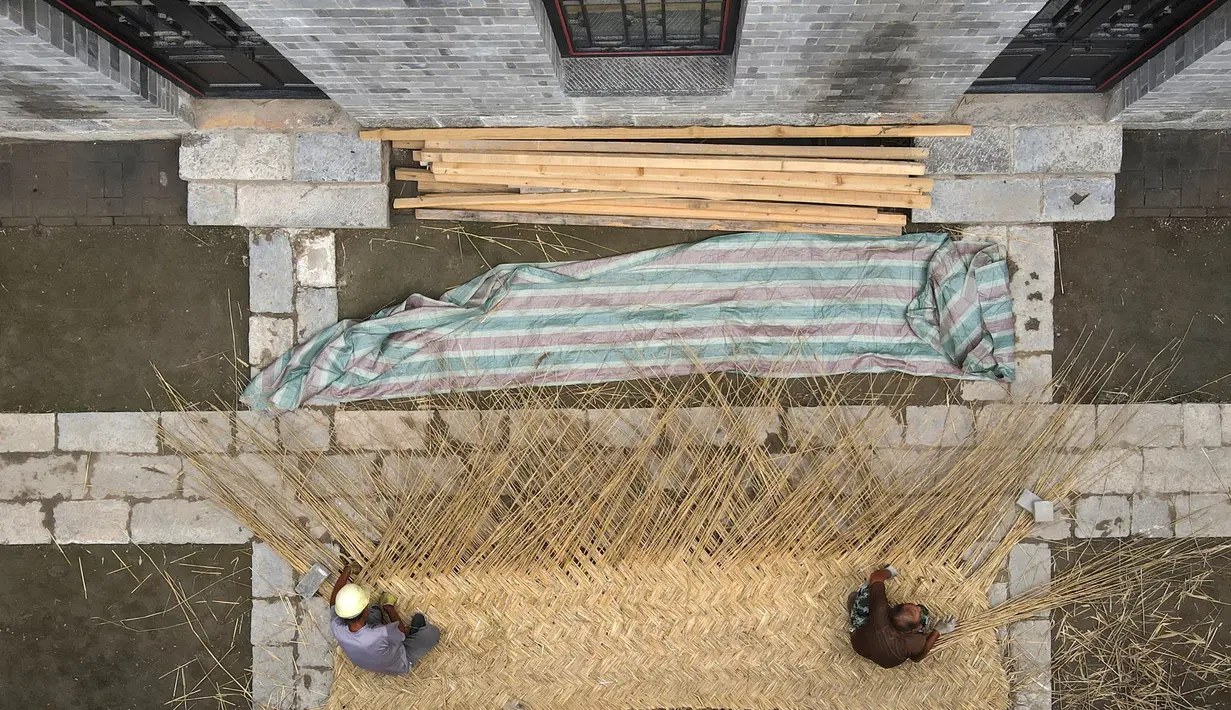 Foto dari udara para pekerja menganyam tikar buluh menggunakan teknik tradisional untuk sebuah rumah kuno di Distrik Xiangdu di Kota Xingtai, Provinsi Hebei, China, 14 Juli 2020. (Xinhua/Zhu Xudong)